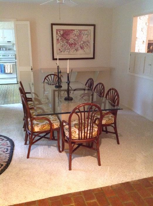 lovely glass top dining table on marble pedestals and 8 rattan chairs