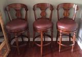 Three tall leather swivel barstools (sold individually).