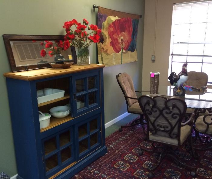 Blue cabinet with sliding doors (possibly Pottery Barn), great rug, glass top table with 4 wrought iron and ultra suede swivel chairs, and tapestry