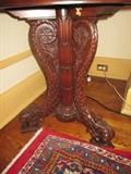 CLOSE UP VIEW OF THIS HIGHLY CARVED MAHOGANY TABLE WITH DOLPHINE LEGS