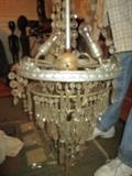 CLOSE UP VIEW OF THIS ANTIQUE HISTORIC CHANDELIER WITH MANY CRYSTAL GLASS PRISMS