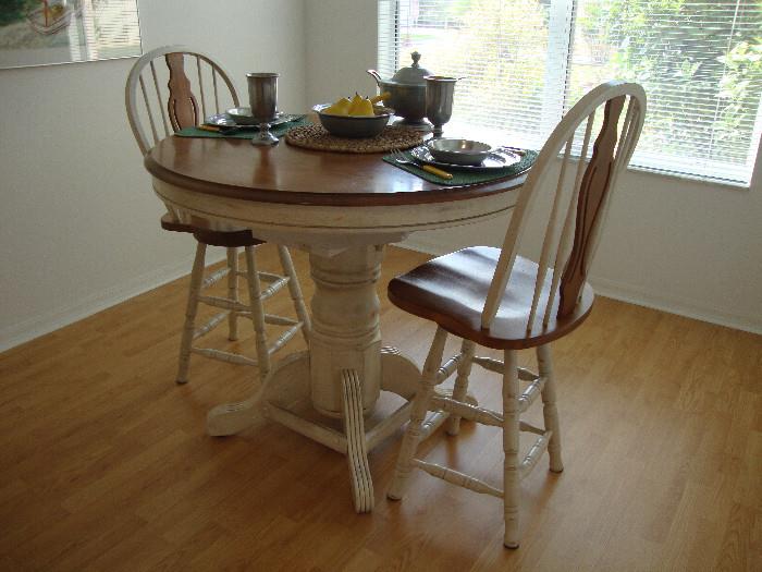 High pedestal table with built-in extension leaf and 2 swivel stools