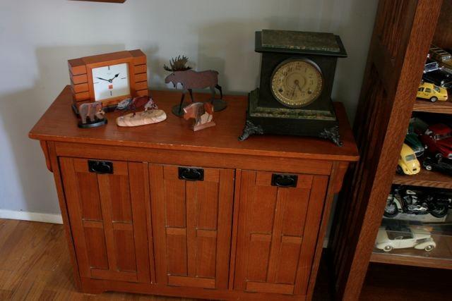 Compact Craftsman style storage cabinet, topped with wildlife themed woodcarvings.