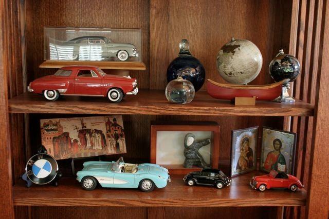 In the entry, open shelving holds an artful display of model cars, art glass, duck decoys and small artwork. 