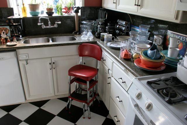 Vintage style throughout the kitchen, including this red vinyl step stool, framed fruit crate labels and colorful Fiesta tableware.