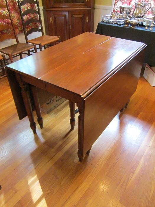 Cherry gate leg dining table with two leaves.