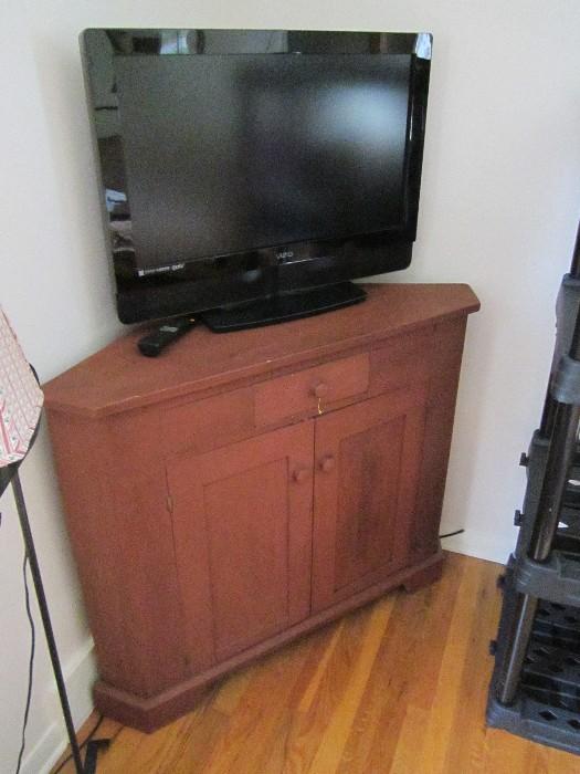 HDTV and antique corner cupboard base.