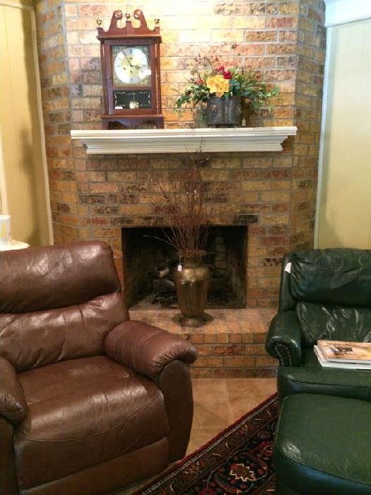 Mantel clock; floral arrangement; brown leather recliner; green leather chair & ottoman