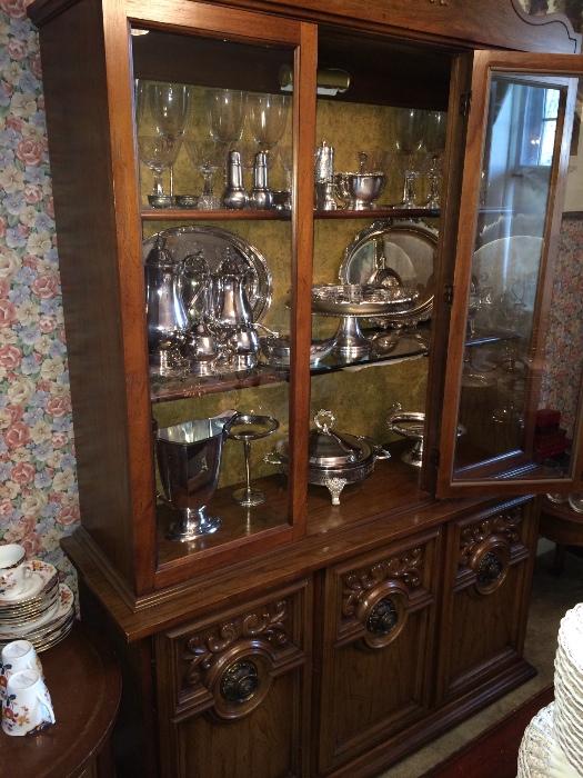 Silver plate items in china cabinet.