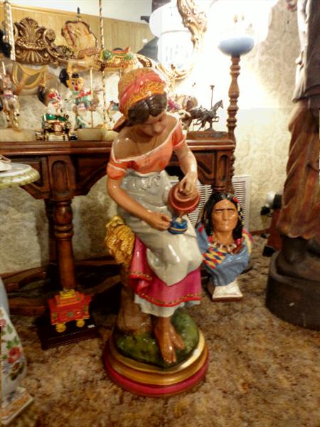 Hand painted plaster maid with water jug, behind is one of two busts of Geronimo and Hiawatha