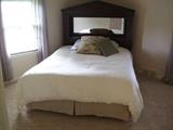 queen bed with wood headboard with mirror inset.