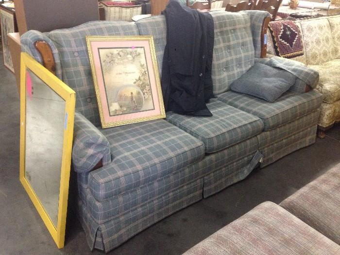 Plaid Blue Couch with Various Artwork displayed on it