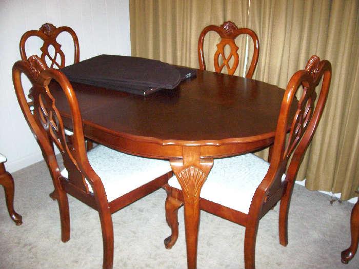 Queen Anne Style dining room table with six chairs and custom table pad.  We did not find a leaf to this table, but we also did not find an additional pad to fit a leaf.  Hmmmm.............