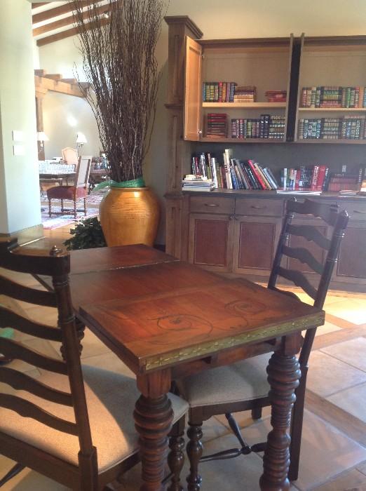 Hand-painted game table and two ladder back chairs with upholstered seats