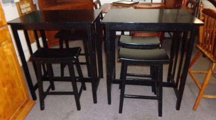 2 black bistro tables with 2 stools each
