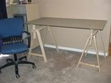 Ikea sawhorse style drafting table with frosted glass table top  (31 1/2 in. x 59 in.).  Adjustable height.  Blue office armchair on rollers.