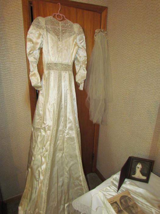 T193-1.jpg	Vintage white satin and lace wedding gown, veil, slip and packing box. We believe that this gown was worn in the late 30's or 40's. The gown has a gorgeous train and detail.
The gown comes with the owner's wedding photo and write up in the Columbus Dispatch.
Also included is the couple's wedding cake topper.
Very good vintage condition