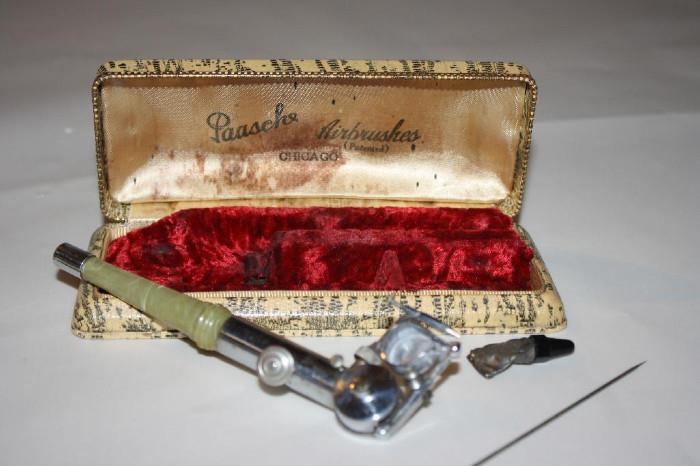 Vintage Air Brush Set: Paasche Air Brush Set with with green marbleized Bakelite handle and velvet lined coffin case. 
Condition: Good