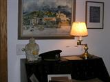 Antique yellow ware rooster humidor (as is), next to WWII navy cap, with William A. Bostick watercolor on wall