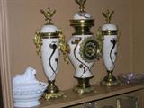 Vintage German garniture, consisting of a clock and pair of covered urns, gilt porcelain with metal mounts.