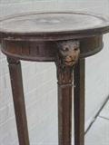 Detail of lion mask motif on antique wood plant stand.