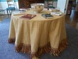 Dining Room:  Large 108 inch gold tablecloth with fringe on top of a 48 inch table.  There are numerous author-signed books on top of the table with a silver plate punch bowl in the center.