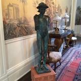 1011 - Life size bronze statue of a lady wearing a hat, 57 in. T, 12 in. Sq.