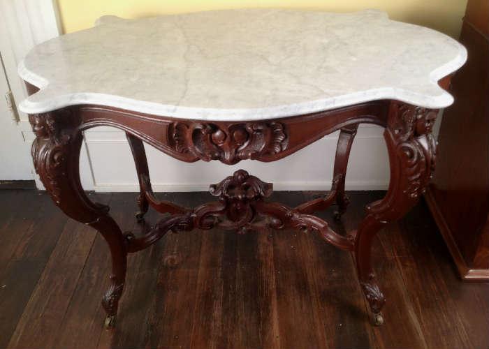 1140 - Walnut Victorian turtle top table with carved ladies heads and stretcher, 29IN T, 44IN W, 30IN D