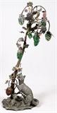 Lot#2, ART NOUVEAU PATINATED METAL & GLASS LAMP, EARLY 20TH C., H 72"Curved tree form lamp, made bundles of multi colored glass grape lights, featuring a seated fox at the base. Measuring H. 72", early 20th Century.