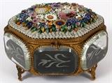 Lot#28, ITALIAN MICROMOSAIC & ETCHED GLASS DRESSER BOX, H 4" L 5"Hexagonal formed dresser box, fitted with 6 bevel glass sides in a gilt metal frame, decorated with a micro mosaic of flowers on white ground at the hinged lid top. Measuring H. 4" x 5".