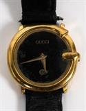 Lot#115, GUCCI LADY'S WRISTWATCH//Swiss quartz movement, with a black dial. Case is base metal with a leather strap band. #14 6600 184. From the Estate of Anne Harnett, Grosse Pointe Park, Mi.