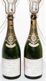 Lot#299, PERRIE-JOUET & CO. CHAMPAGNE BOTTLE LAMPS, 1928, PAIR, H 26"Perrier-Jouet & Company glass champagne bottles mounted as table lamps. Dated 1928, measuring H. 15" and H. 26" overall.