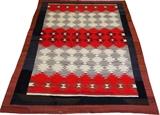 Lot#1328, NAVAJO HAND WOVEN RUG, C. 1920, 8' 8" X 6' 4"Decorated in all over stylized geometric design on a red and ivory ground, with brown and black borders. Measuring L. 8 ft. 8 x 6 ft. 4. Circa 1920.