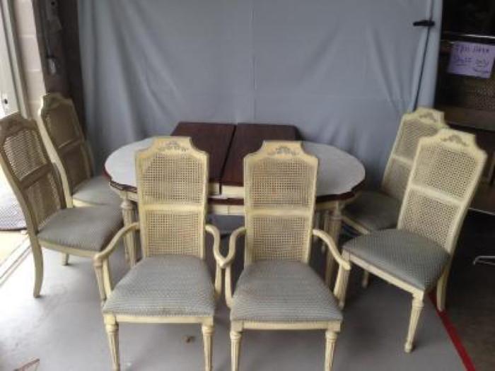"Stanley Furniture" Dining Room Set: This is a sturdy oval shape table that is dark colored wood on top and has off white colored legs. The edge of the table is carved out on the ends. The table comes with 4 table pads that are white, and 2 leaves. The 6 chairs are open lattice on the back, upholstered with a subtle peach and blue fabric, and two of the chairs have arms. This set would fit into any dining room decor. The table measures: 42"W x 64.25"L and 29.50"H. The chairs measure: 41.25"H, the seat is 18.50" x 17", and the seat measures 17.50" from seat to floor. The leaves measure: 42"L x 16"W. The seats on these chairs are stained but could easily be reupholstered. 