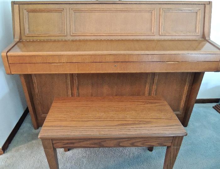 Wurlitzer piano with practice mode lever and matching bench.
