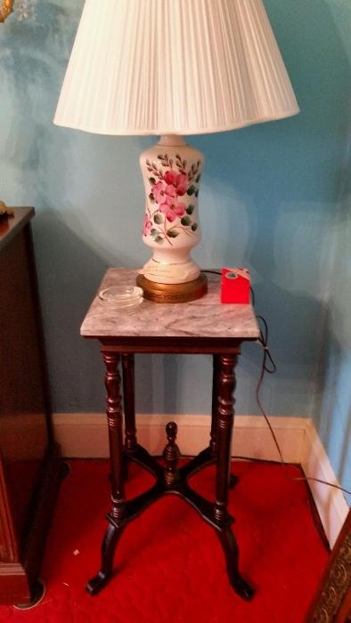 One of a pair of bristal lamps and one of a pair of marble top tables