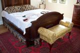 Footboard of the Victorian bed - it is a double bed. Pretty upholstered bench at the foot of the bed - antique room size oriental rug - in excellent condition.