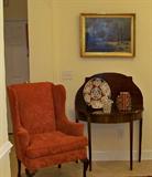 Beautiful wing chair with expensive upholstery- mahogany card table, with an Imari charger. The charger is old