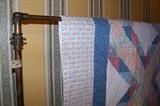 The quilt is hanging on a wonderful brass and copper clothing rack - made in England. The rack has a wonerful iron ornate base, shown in one of the pictures.
