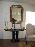 Stunning and elegant large gold carved mirror, art deco console table and huge clear chunky glass vase.