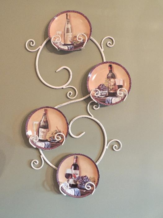 Decorative metal scrollwork plate rack, and wine still-life motif plates.