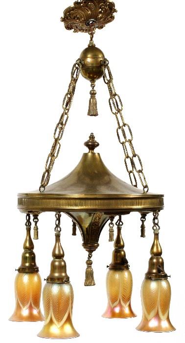 Lot#1004, STEUBEN AURENE GLASS SHADES & BRASS FOUR-LIGHT CHANDELIER, EARLY 20TH C., H 6 1/4", 33" OVERALL//Brass 4-light chandelier fitted with four Steuben gold aurene glass shades, decorated in pulled feather design, including one extra; each is acid etch marked at the top rim, measuring H.6 1/4". Circa early 20th Century.  The fixture measures approximately H.27", Dia.12".