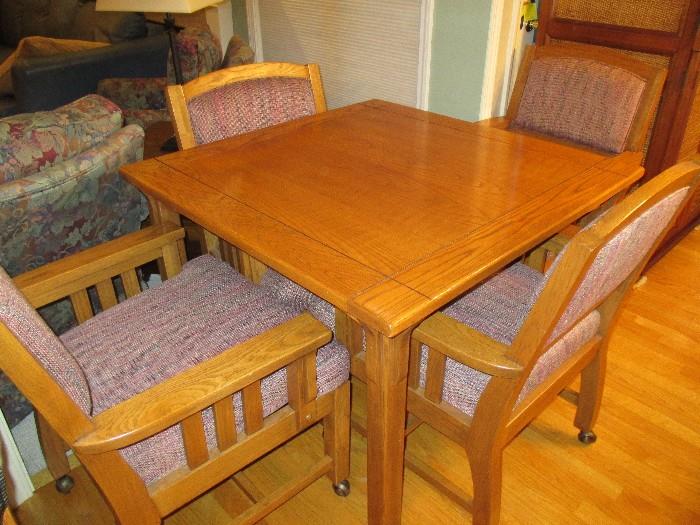 Oak square kitchen or game table with 4 rolling arm chairs.