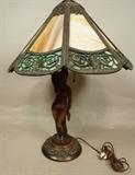 Lot 20  -  Slag glass table lamp with carved figural wood base. Female nude carved wood with green and amber slatted glass wood shade. label underneath Scott E. Barwis. October 2, 1928.-- Dimensions:  H: 22 inches: W: 17 inches: D: 17 inches --- 