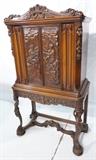 Lot 80  -  Fancy Heavily Carved Radio Cabinet.  Tall 2 Door Cabinet on Figural Legs.  Overall Carving.  Scenic.  No components.-- Dimensions:  H: 66 inches: W: 37.5 inches: D: 19.5 inches --- 