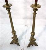 Lot 86  -  Pair Tall Brass Candlesticks/  Column form with portrait base.  Tall wax candle. -- Dimensions:  H: 66 inches: W: 9 inches --- 