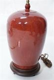 Lot 109  -  Asian Pottery Lamp in Red Glaze with Wood Base.  -- Dimensions:  H: 31 inches: W: 9 inches --- 