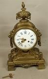 Lot 200  -  Vintage Brass Mantle Clock with Lion Head Handles.  Porcelain face.  Urn Top.-- Dimensions:  H: 18 inches: W: 10.5 inches: D: 5.5 inches --- 