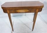 Lot 55  -  Antique Sheraton style flip top game table. Tapered legs, pencil inlay.-- Dimensions:  H: 29.5 inches: W: 34 3/4 inches: D: 16 3/4 inches --- 
