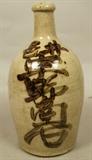 Lot 325  -  Asian Pottery Glazed Vase. Brown Glazed Asian Characters on long necked form pottery vase. -- Dimensions:  H: 10.5 inches: W: 5 inches ---  <br><br>US Shipping charge:</b>  $35